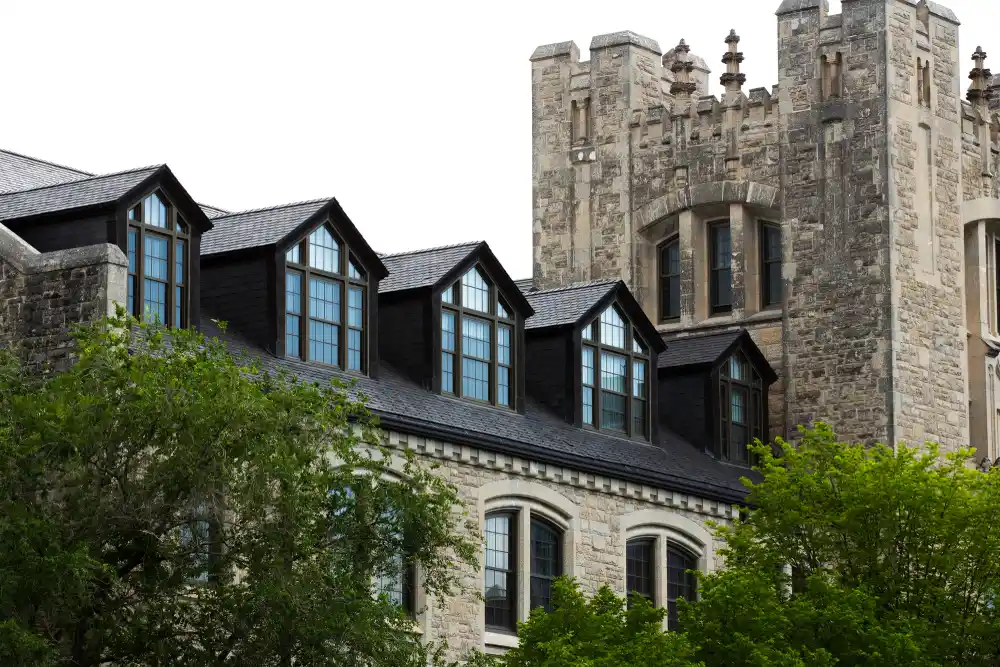 An old castle tower made from stone with a new extension added to the side made of glass. This is here to show the G&M Building Contractors can refurbish the old structures whilst delivering new extensions too.